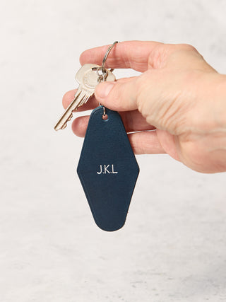 Navy leather art deco inspired keyring with a monogram of J.K.L stamped on it in silver text.