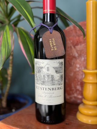 Leather label attached to a bottle of red wine.