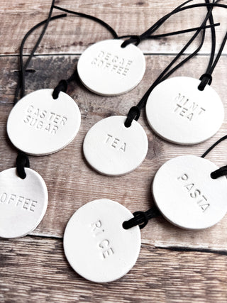 Minimalist white leather pantry tags with hand-stamped labels for kitchen storage. Rustic and stylish labels with black cord, ideal for home organisation and pantry décor