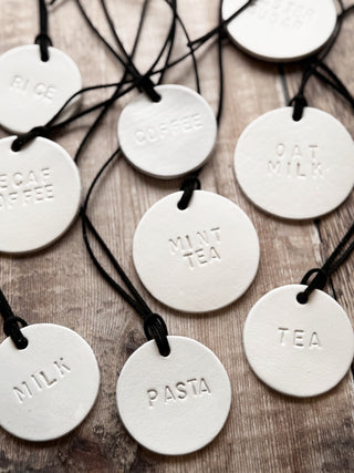 Minimalist white leather pantry tags with hand-stamped labels for kitchen storage. Rustic and stylish labels with black cord, ideal for home organisation and pantry décor