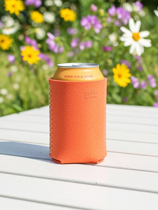 Can with an pink leather sleeve on a table with a floral background