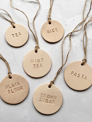 Handmade round leather label with "MILK" embossed, attached to a glass bottle with jute string. Ideal for rustic kitchen styling, pantry storage, or customisable home organisation