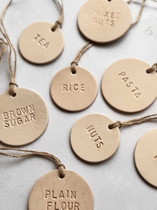 Handmade round leather label with "MILK" embossed, attached to a glass bottle with jute string. Ideal for rustic kitchen styling, pantry storage, or customisable home organisation